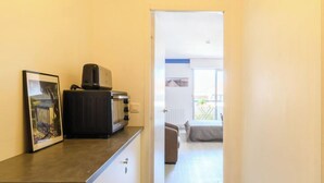 Passadís estret que condueix a un balcó amb un llit i una finestra.