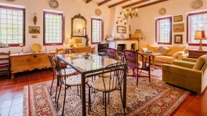 Un salon spacieux avec une table à manger en bois, des chaises, un canapé et une cheminée.