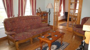 Una sala de estar con un sofá, una mesa de centro, una lámpara y una estantería.