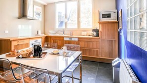 Eine moderne Küche mit Holzschränken, einer weißen Arbeitsplatte und einem großen Fenster für natürliches Licht.