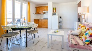 A compact living space with a dining area, kitchenette, and a sofa with patterned cushions. - La Sirene by Interhome (Saint Cyr sur mer Les Lecques)
