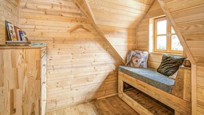 A cozy attic bedroom with wooden walls and a sloped ceiling. - Plitvice I by Interhome (Plitvice)