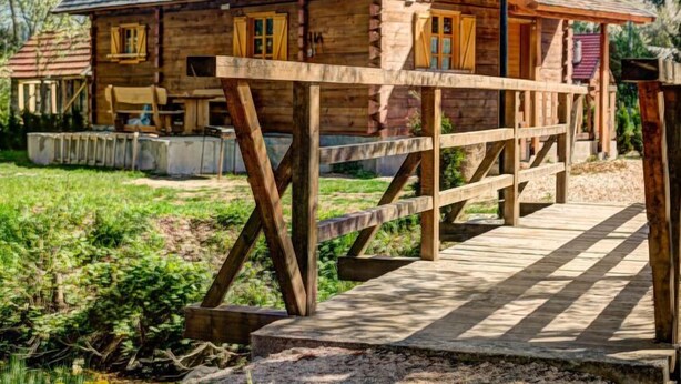 A wooden cabin with a sloped roof, a wooden deck, and a small porch. - Plitvice I by Interhome (Plitvice)