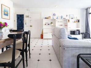 Uma sala de estar moderna com sofá, mesa de jantar, cadeiras e estante.