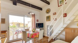 A cozy room with a dining area, a TV, and a staircase. - Les Maldives by Interhome (Cap d'Agde)
