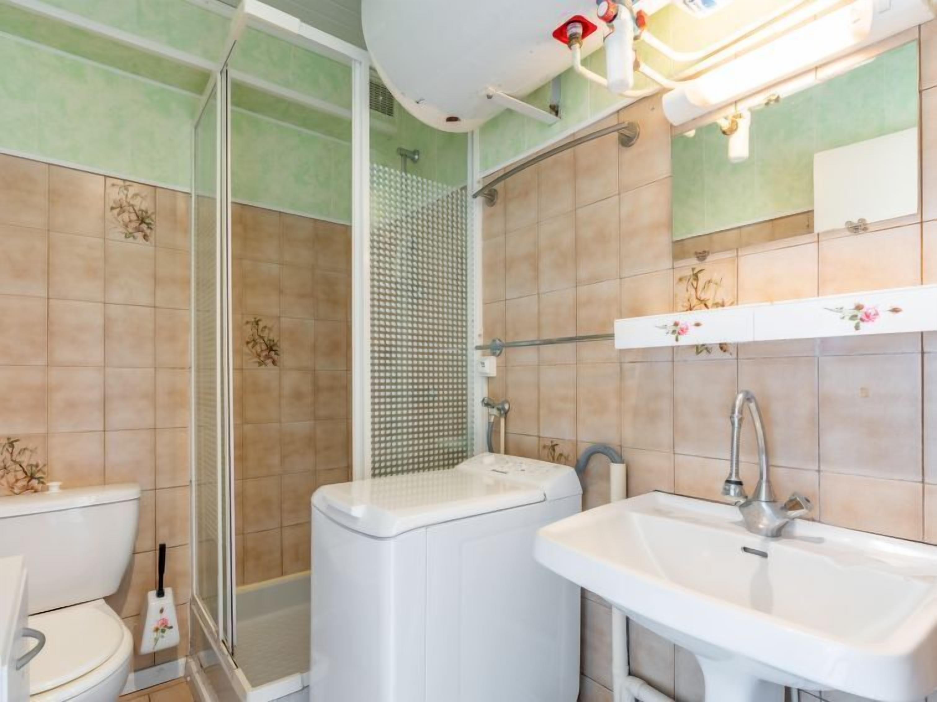 A bathroom with a toilet, a sink, and a shower area.