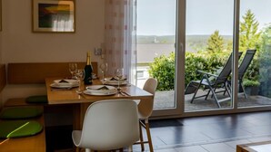 Ein Essbereich mit einem Tisch für zwei Personen, einer Champagnerflasche und einem Gemälde an der Wand.