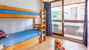 A bunk bed room with a view of a building and a balcony. - Lunik Orion by Interhome (Le Corbier)