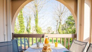 A breakfast table set on a balcony with a view of trees and greenery. - Les Bastides de Grand Stade by Interhome (Saint Cyprien)