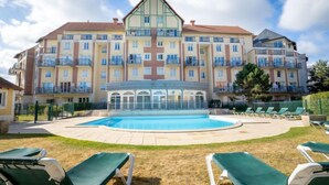 Un hôtel doté d’une piscine entourée de chaises longues.