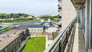 Un immeuble de grande hauteur doté d’un jardin sur le toit, d’un pont piétonnier et offrant une vue sur la plage et les dunes.