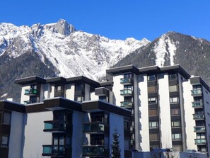 A modern hotel with multiple floors and balconies, set against a backdrop of snow-capped mountains. - L'Aiguille du Midi by Interhome (Chamonix)
