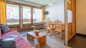 Una habitación acogedora con una cama, una mesa de madera y un comedor con sillas.