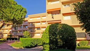 A multi-story hotel with a uniform exterior, balconies, and a well-maintained garden area. - Les Vignes by Interhome (Saint Cyr sur mer Les Lecques)