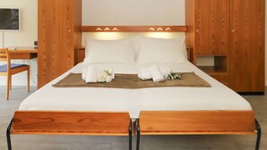A double bed with white linens, a wooden headboard, and a bedside table with a lamp. - Matten (Utoring) by Interhome (Zermatt)