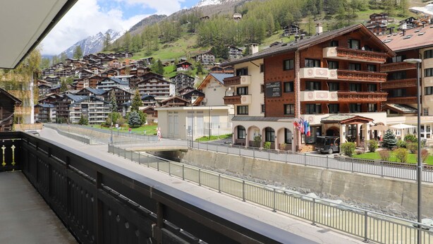 A hotel with multiple floors, balconies, and a view of a mountainous landscape. - Matten (Utoring) by Interhome (Zermatt)