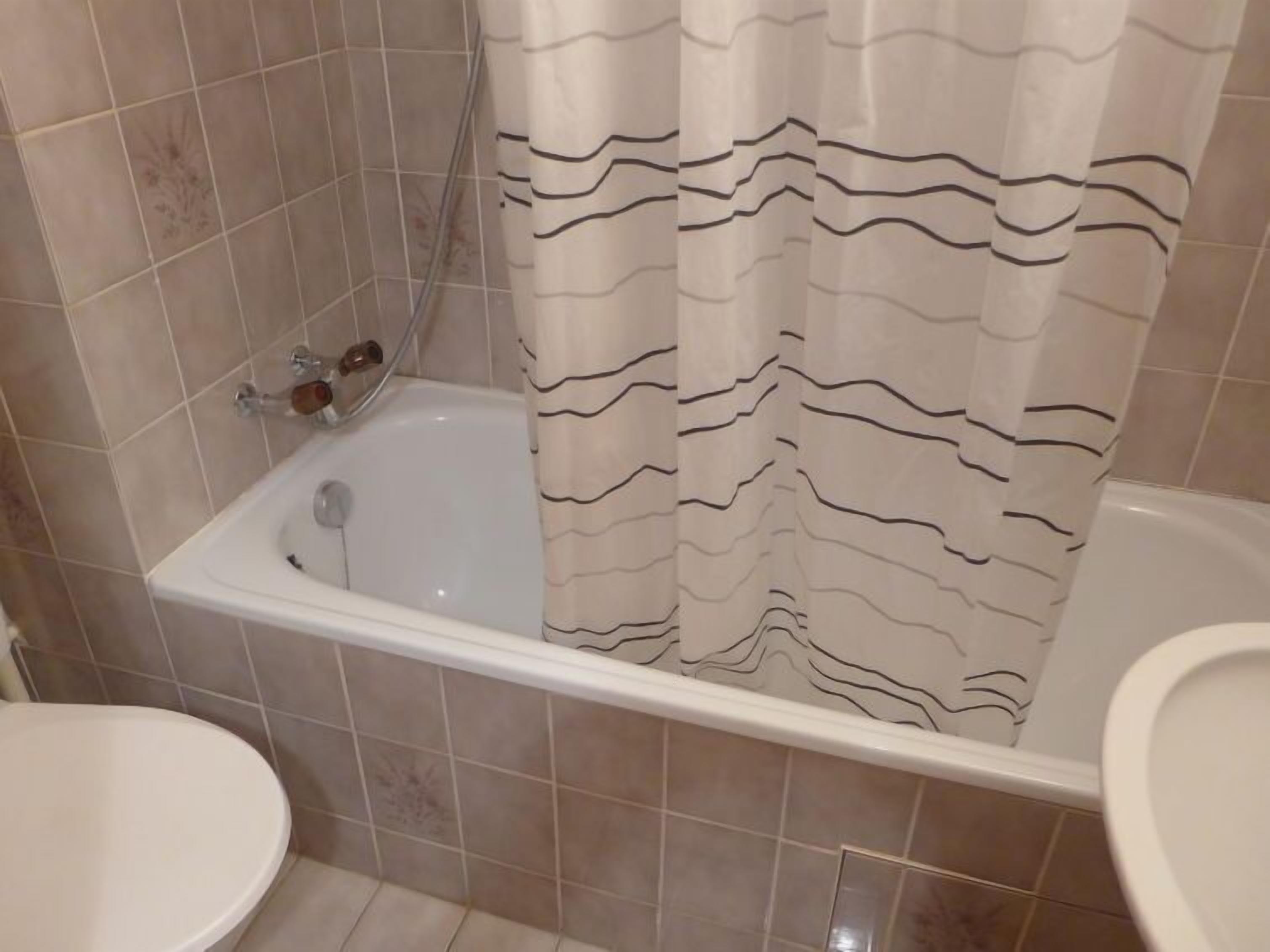 A bathroom with a bathtub, a shower, and a toilet.