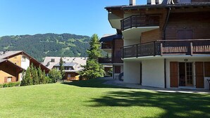 Un edificio in stile chalet tradizionale, con un balcone e vista su un paesaggio montano.