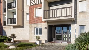 Ein mehrstöckiges Gebäude mit Ziegelaußenwand, einem Balkon mit Metallgeländer und einem verschlossenen Eingang.