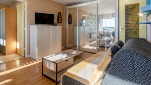 Ein modernes Wohnzimmer mit einer Couch, einem Couchtisch und einem Fernseher auf einer Kommode.