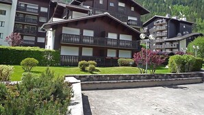A multi-story building with balconies, surrounded by greenery and mountains. - Clos du Savoy by Interhome (Chamonix)