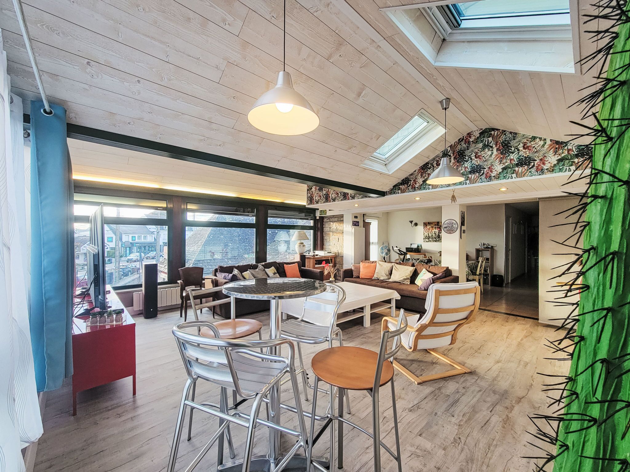 Un vaste espace de vie doté d’un haut plafond, de grandes fenêtres et d’un coin salon confortable.