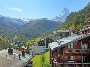 A mountain village with traditional wooden houses, a prominent mountain peak in the background, and a clear sky. - Lauberhaus by Interhome (Zermatt)