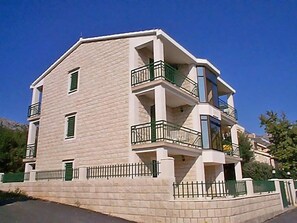 A multi-story building with balconies, a brick facade, and a gated entrance. - Apartment Orebić by Interhome (Orebić)
