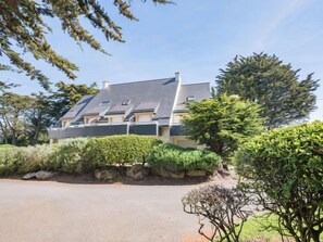 A modern two-story house with a sloped roof, a stone retaining wall, and a paved driveway. - Rose des Vents by Interhome (Quiberon)