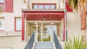 A building entrance with a red awning, a glass door, and a staircase leading up. - la Pergola by Interhome (Hossegor)