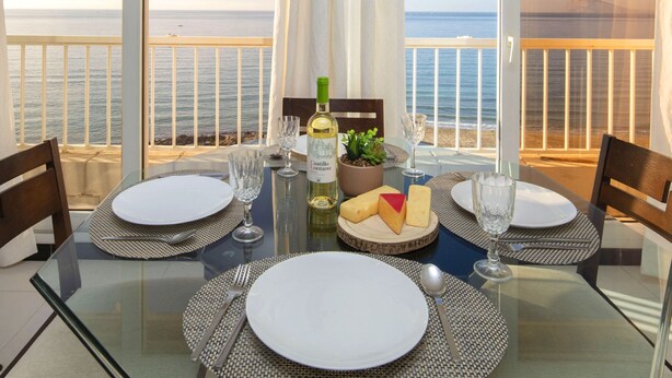 A dining table set for two with a view of the sea. - Les Roquetes by Interhome (Calpe/Calp)