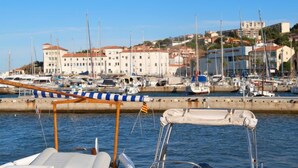 Un puerto deportivo con barcos amarrados, un muelle y edificios al fondo.