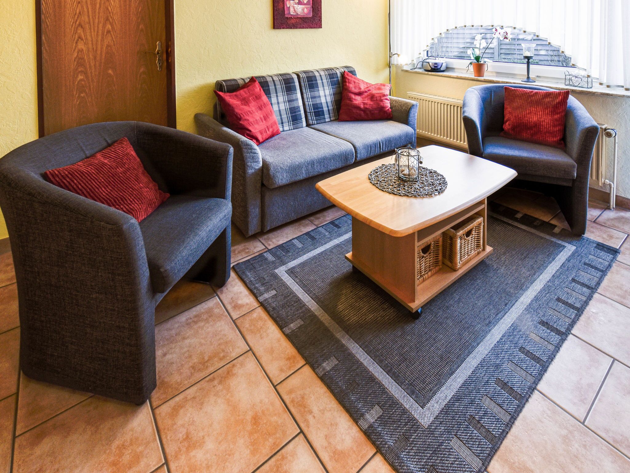 Una sala acogedora con dos sillones, un sofá y una mesa de centro.