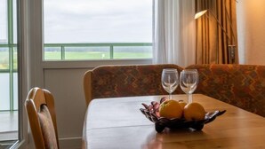 A dining area with a table set for two, a bowl of fruit, and two wine glasses. - Apartment K 40 by Interhome (Dittishausen)