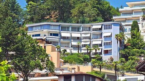 A multi-story hotel with balconies, surrounded by trees and other buildings. - Suite Classic by Interhome (Ascona)