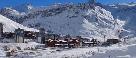 A snow-covered mountain town with buildings and a ski lift.