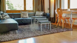 Un salon moderne comprenant un canapé, une table basse et un coin repas avec une chaise et une table.