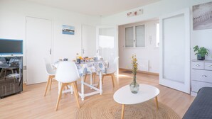 A modern living room with a dining area, a television, and a plant. - Bellevue by Interhome (Quiberon)