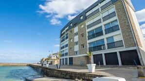A multi-story building with balconies, a stone facade, and a waterfront view. - Bellevue by Interhome (Quiberon)