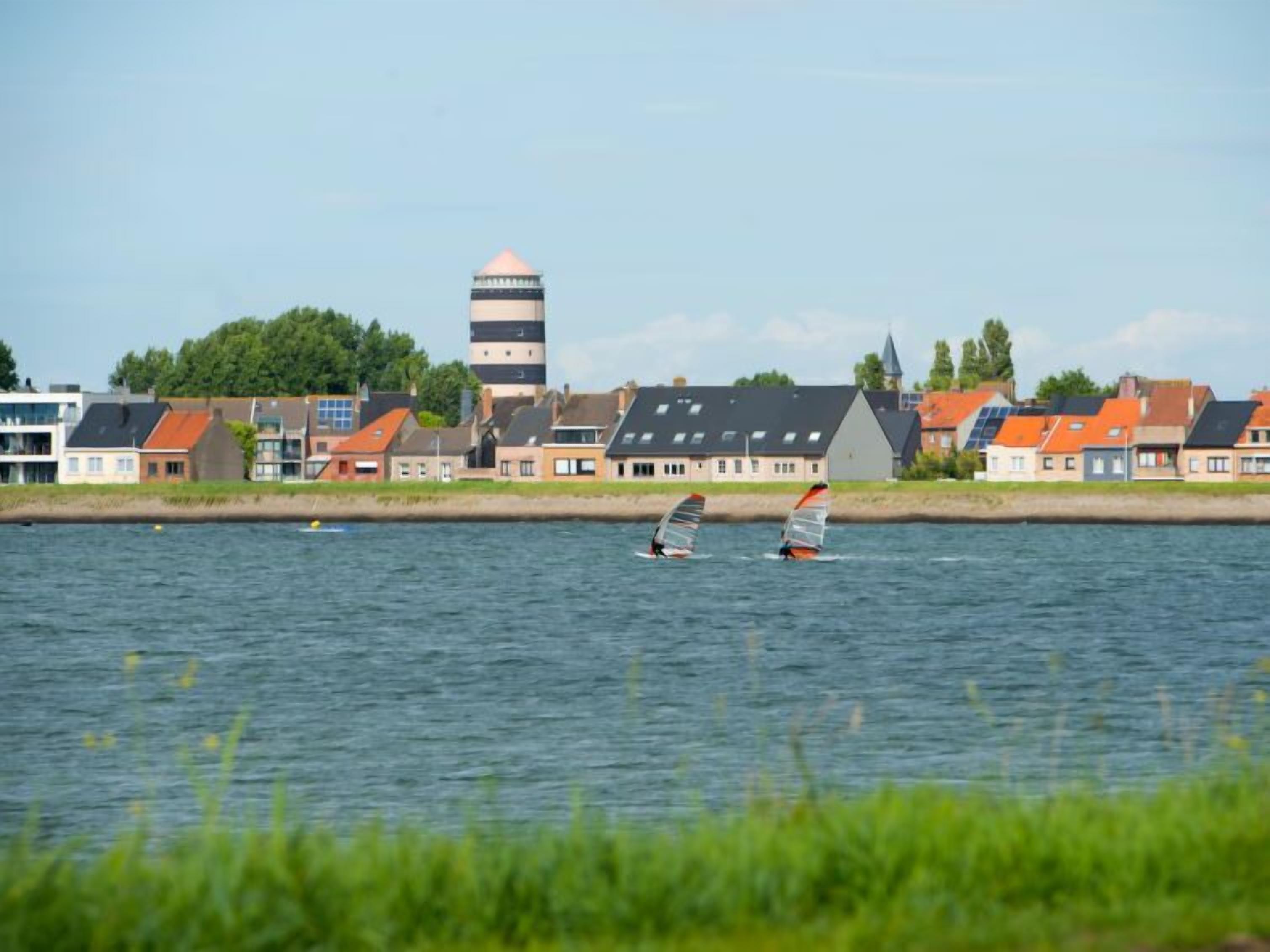 Vista al agua con casas y una torre.
