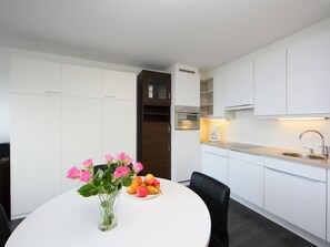 Enjoy meals in this kitchen with oven, stainless steel sink, and round dining table.