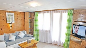 Ein Wohnzimmer mit einer Couch, einem Couchtisch und einem Fernseher.