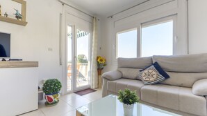 A modern living room with a sofa, a coffee table, and a TV on a stand. - El Santiago II by Interhome (Roses)
