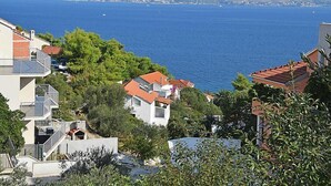 A coastal residential area with houses, some with balconies, and a view of the sea and mountains in the background. - Molo Lozna by Interhome (Brač/Postira)