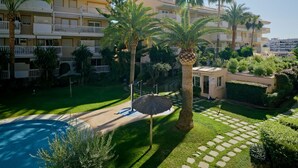 A hotel courtyard with a swimming pool, palm trees, and a well-maintained garden. - Nou Fontana by Interhome (Jávea)