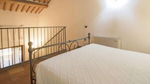 Ein Schlafzimmer mit Bett, Fenster und Holzboden.