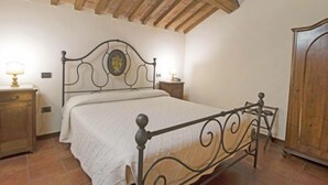Ein Schlafzimmer mit einem Bett, einem Holzschrank und einem Nachttisch mit einer Lampe.