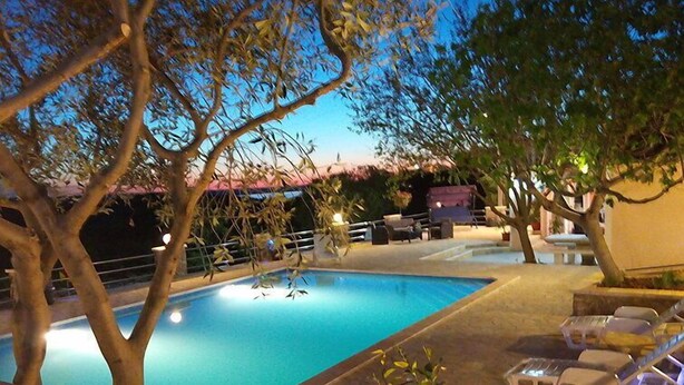 Piscina com espreguiçadeiras e área de terraço.