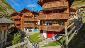 Un hotel de estilo chalet de madera con varios balcones y un telesilla al fondo.