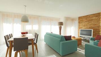 A modern living room with a sofa, TV, and dining area.